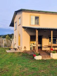ein Haus mit einer Holzterrasse im Hof in der Unterkunft Yad elohai pousada israelense in Campo Alegre