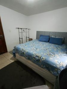 a bedroom with a bed with blue sheets and blue pillows at AP do Vale em Blumenau in Blumenau +5 photos