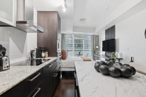 a kitchen with a table with a bowl of fruit on it at Stylish Downtown Studio with CN Tower Views in Toronto