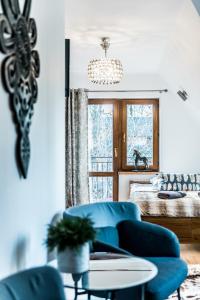 een woonkamer met een blauwe bank en een raam bij Willa u Baranów 2 in Zakopane
