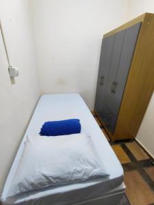 a small room with a bed and a cabinet at Hospedagem Residencial Butantã in Sao Paulo