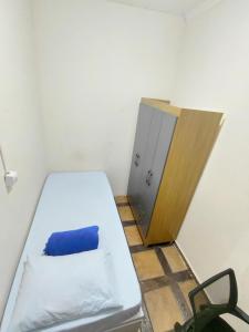 a small room with a bed and a door at Hospedagem Residencial Butantã in Sao Paulo