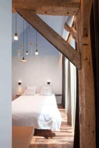 een slaapkamer met een wit bed in een kamer bij Hotel Restaurant Vous lé Vous in Hasselt