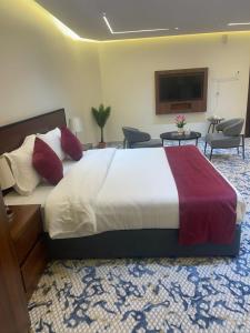 une chambre avec un grand lit dans une pièce dans l'établissement سفانة هلا للشقق المخدومة, à Hafr Al Baten