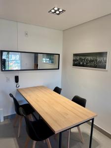 a conference room with a wooden table and chairs at Studio 107 Home Com Varanda, Ar-condicionado e Netflix in Mogi das Cruzes +80 photos