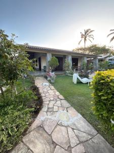 a garden with a stone path in front of a house at Casa do Kite in Cumbuco