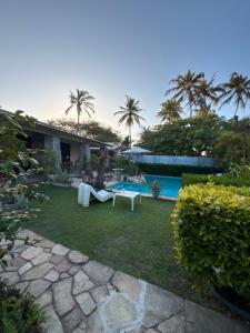 a backyard with a swimming pool and a house at Casa do Kite in Cumbuco