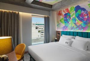 a bedroom with a large bed and a window at NYX Hotel Thessaloniki in Thessaloniki