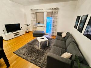 a living room with a couch and a tv at Düsseldorf Apartment in Düsseldorf