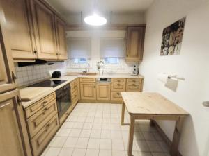 a kitchen with wooden cabinets and a table in it at Düsseldorf Apartment in Düsseldorf