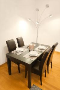 a black dining room table with black chairs and a lamp at Düsseldorf Apartment in Düsseldorf