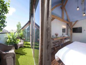 1 dormitorio con 1 cama y balcón con césped en Hotel Restaurant Vous lé Vous, en Hasselt