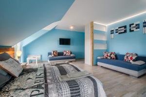 un soggiorno blu con un letto e un divano di Villa Bryza a Mechelinki