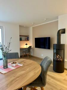 a living room with a wooden table and a fireplace at H24ZINGST - Das Ferienhaus in Zingst