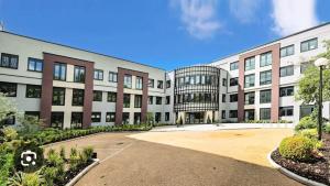 an apartment building with a parking lot in front of it at Brand new luxury apartment with free parking and gym in Olton