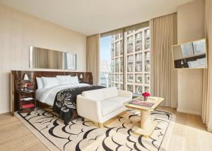 ein Schlafzimmer mit einem Bett und einem Stuhl und einem Fenster in der Unterkunft Faena New York in New York