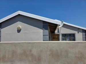 a house with a window on top of a concrete wall at Ngwanase Properties in Vosburg