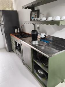 a kitchen with a stove and a sink and a refrigerator at Cantinho do Sossego in Campo Alegre +19 photos