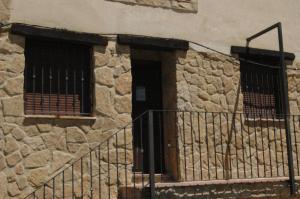 un edificio de piedra con 2 ventanas y una puerta en Apartamento Valdenieve, en Valdelinares
