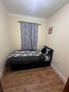 a bedroom with a bed with a curtain and a window at Double & Single rooms in Southall in Southall
