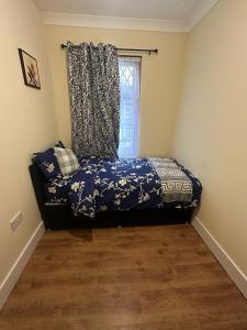 a bedroom with a bed with a curtain and a window at Double & Single rooms in Southall in Southall