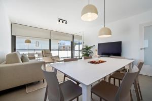 un soggiorno con tavolo e sedie bianchi di Hauzify I Apartaments Coral a Torredembarra Altre 21 foto