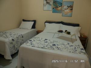 塞古罗港Pe no Centro的一间卧室配有两张床和一盘食物