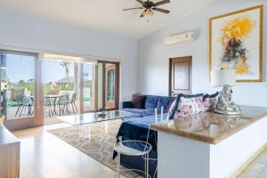 a living room with a blue couch and a table at Casa Reyes -All in One, Heated Pool & Beach Access in El Pueblito