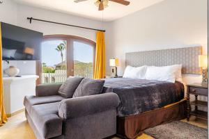 a bedroom with a bed and a couch and a window at Casa Reyes -All in One, Heated Pool & Beach Access in El Pueblito +51 photos