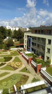 a large building with a courtyard in front of it at Apartament Perełka Zielone Tarasy Kołobrzeg in Kołobrzeg