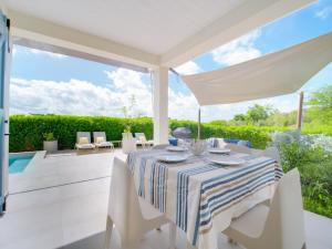 Un comedor blanco con una mesa y sillas. en SeaRock & SeaShell Villas, en Le Diamant