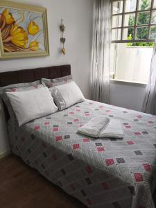 a bed with two pillows and a quilt on it at Cantinho do Sossego in Campo Alegre
