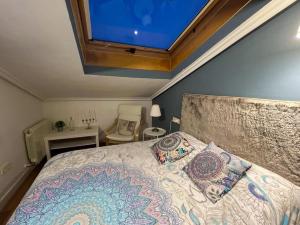 une chambre avec un grand lit avec une grande fenêtre dans l'établissement La Casa de la Luna, à Ávila