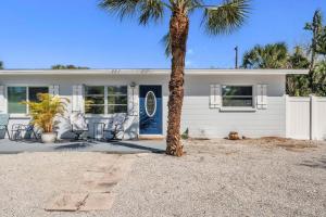 eine Palme vor einem weißen Haus in der Unterkunft Barefoot Bungalow home in Anna Maria Island