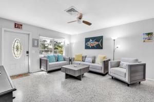 ein Wohnzimmer mit Sofa, Stühlen und einem Tisch in der Unterkunft Barefoot Bungalow home in Anna Maria Island