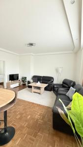 ein Wohnzimmer mit einer schwarzen Couch und einem Tisch in der Unterkunft Arm Apart in Brüssel