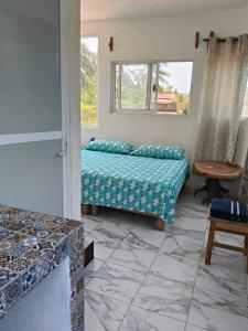 ein Schlafzimmer mit einem Bett und einem Tisch und einem Fenster in der Unterkunft Fiesta Zipolite in Zipolite + 7 Fotos