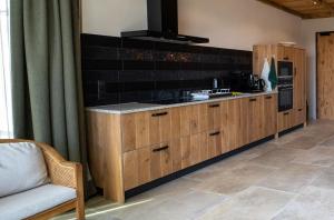 kuchnia z drewnianymi szafkami i kuchenką w obiekcie Hof van Kleeberg w mieście Mechelen