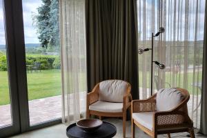 dwa krzesła i stół przed oknem w obiekcie Hof van Kleeberg w mieście Mechelen