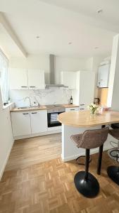 eine Küche mit weißen Schränken und einem Holztisch in der Unterkunft Arm Apart in Brüssel
