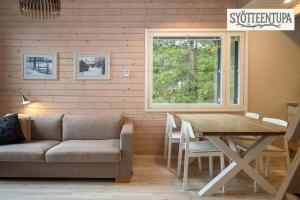a living room with a table and a couch at Syötteentupa in Syöte