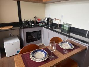 une cuisine avec une table avec des assiettes et des verres à vin dans l'établissement Monakó Cabanas, à Bragança Paulista