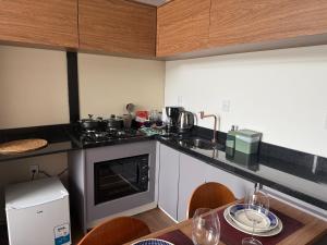 une cuisine avec une cuisinière et une table avec des chaises dans l'établissement Monakó Cabanas, à Bragança Paulista