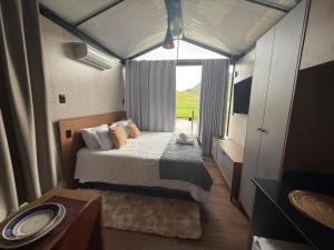 une chambre avec un lit et une grande fenêtre dans l'établissement Monakó Cabanas, à Bragança Paulista 58 autres photos
