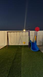 een speeltuin met twee schommels bij Bain Al Qimam in Hatta