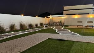 a garden at night with a pathway and a building at Bain Al Qimam in Hatta