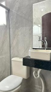 a bathroom with a toilet and a sink and a mirror at Casa em Santo André -SP in Santo André