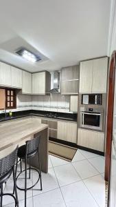 a kitchen with a counter and two chairs in it at Casa em Santo André -SP in Santo André +11 photos