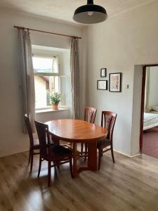 Un comedor con mesa y sillas de madera. en Apartmán Ekonomy, 