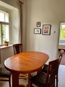 Una mesa y sillas de madera en una sala de estar. en Apartmán Ekonomy, 